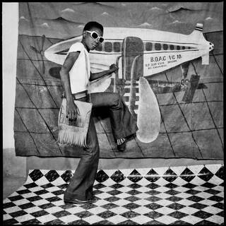 Black and white photo of person stepping onto a plane image on a backcloth 