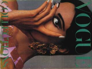 Black model wearing smoky winged-eyeliner and elaborate gold earrings. Her hair is short and she covers her face.