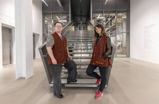 Two people standing at the bottom of a set of stairs