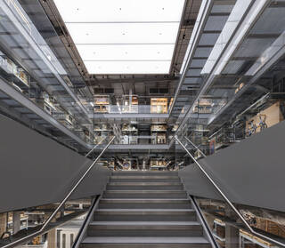 Staircase leads to a large warehouse style space with shelving and museum objects