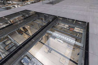A glass floor with museum objects and storage below