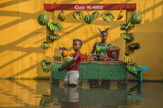 women's fruit and vegetable stall in flooded area