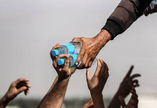Handing out two bottle of water to outstretched arm